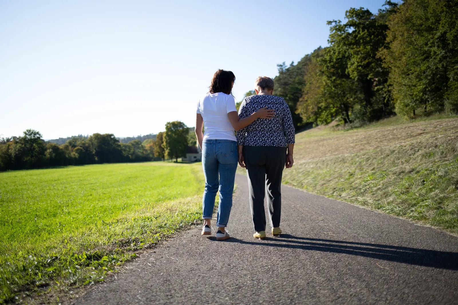 Pflegefachfrau begleitet eine Klientin beim Spaziergang
